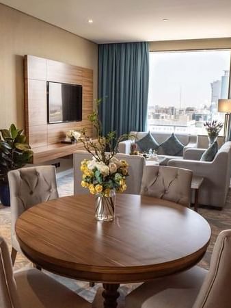 Executive Suite features Round wooden table with chairs by a living area at Cantonal Hotel by Warwick Riyadh