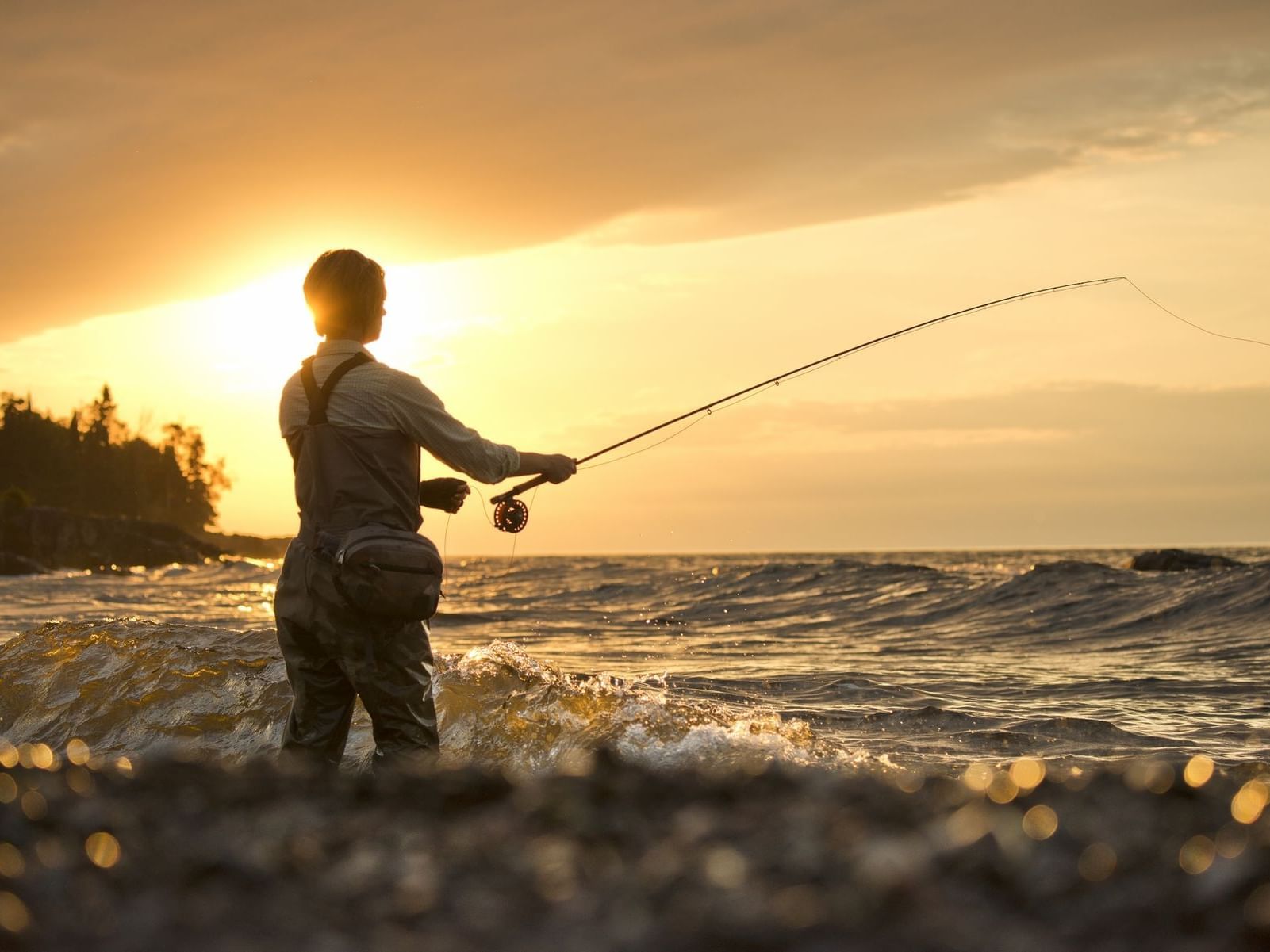 A man fishing in the beach at Lutsen Resort