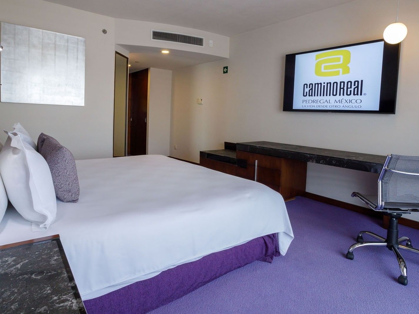 King Camino Real Club at Camino Real Pedregal Mexico, showing a branded TV screen, work area, and purple carpeting
