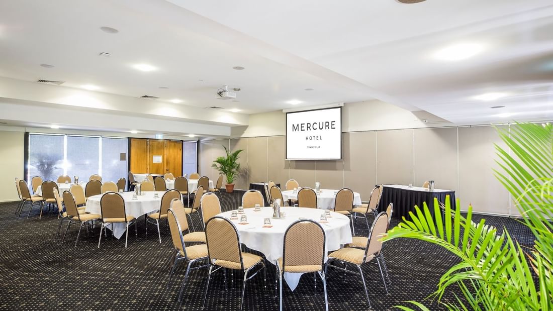 Interior of Burdekin Room featuring u-shape table setup, chairs and a projector screen at Mercure Hotel Townsville