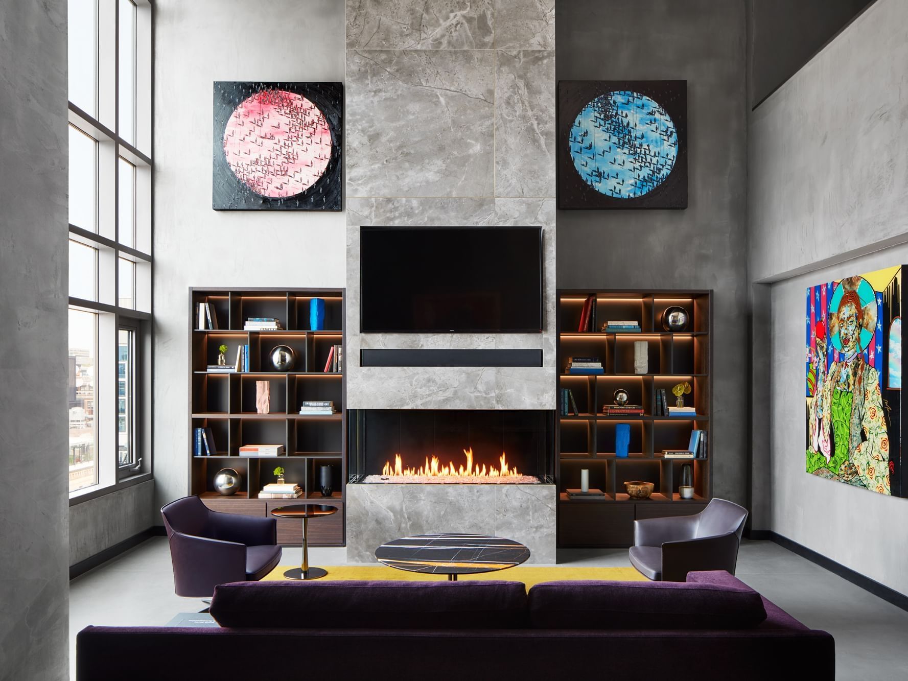 Penthouse suite with couch, chairs, a tv, bookshelves, and art on the wall