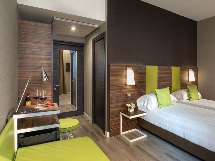 Superior Room featuring two twin beds, a seating area, and a refreshment station with wine and snacks at The Republic Hotel