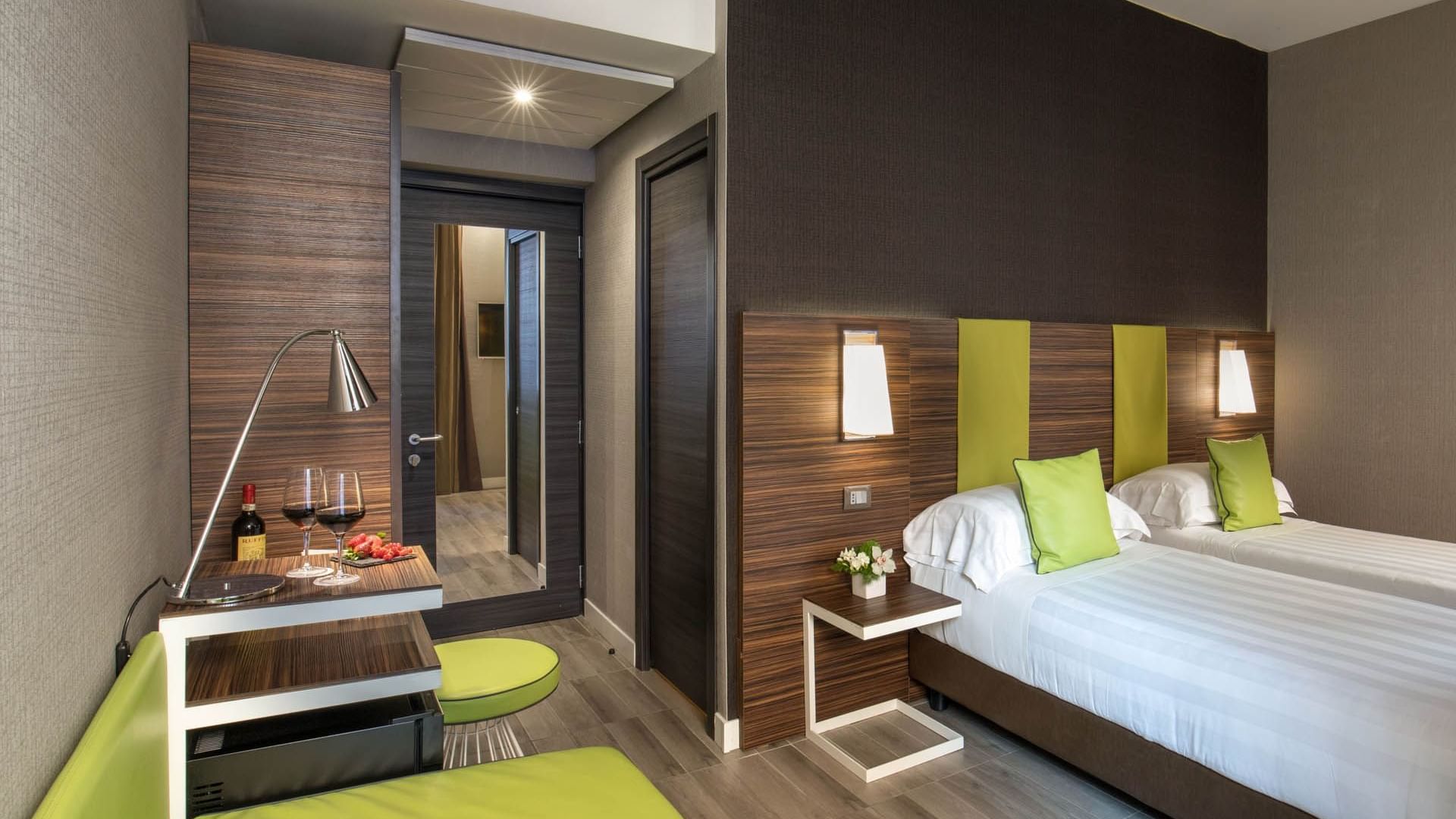 Superior Room featuring two twin beds, a seating area, and a refreshment station with wine and snacks at The Republic Hotel
