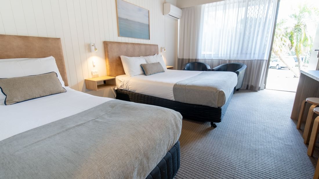 Picturesque art hung by the beds in Standard Twin Room with loungers by the window at Mercure Charlestown