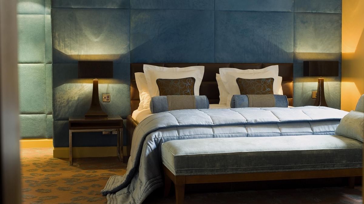 Bedroom in The Azure Suite at The May Fair Hotel, London, featuring a large bed flanked by stylish lamps