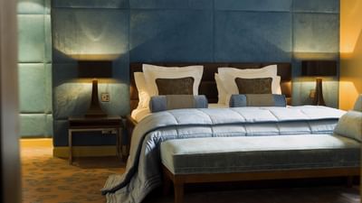 Bedroom in The Azure Suite at The May Fair Hotel, London, featuring a large bed flanked by stylish lamps