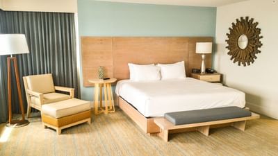 Bright, modern King Corner Suite, featuring coastal decor and a sun mirror at Margaritaville Resort Biloxi
