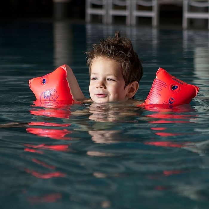 A kid in the pool with floats at Falkensteiner Hotel Sonnenalpe