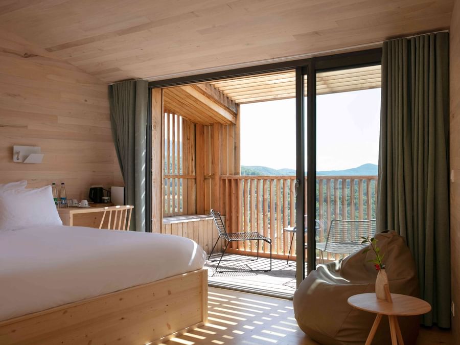 A bedroom with balcony & large bed at The Originals Hotels
