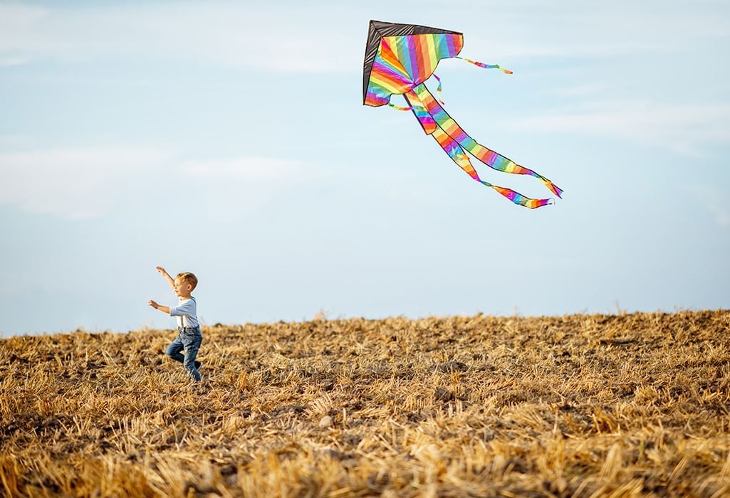 Kid with kite in the sky that spell windscape