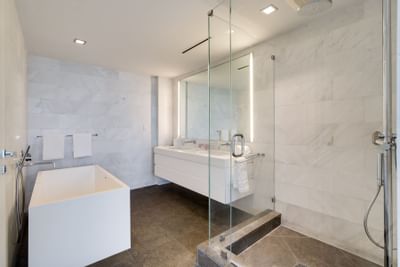bathroom with white bathtub, walkin shower and large white vanit