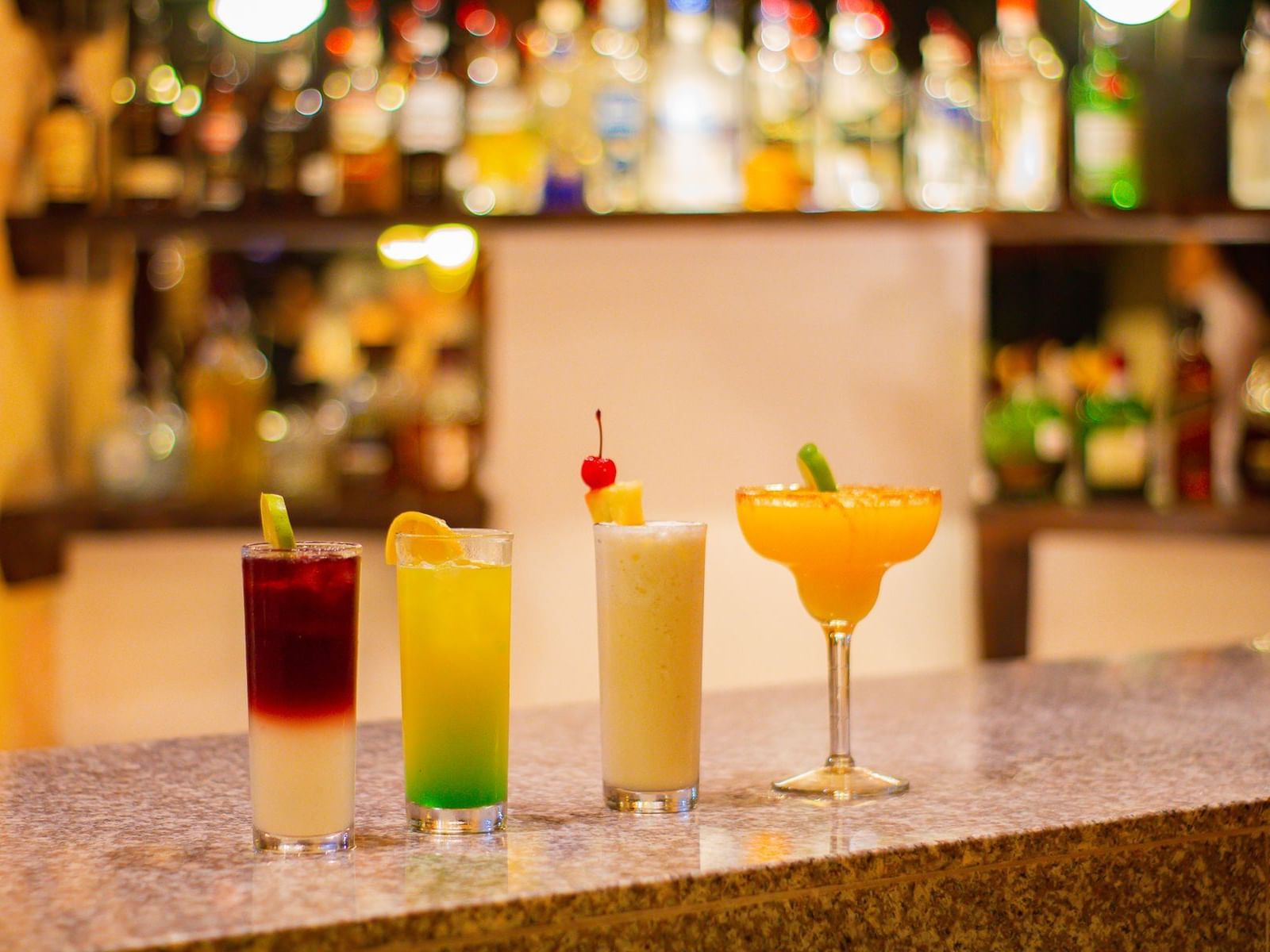 row of mixed drinks at a bar