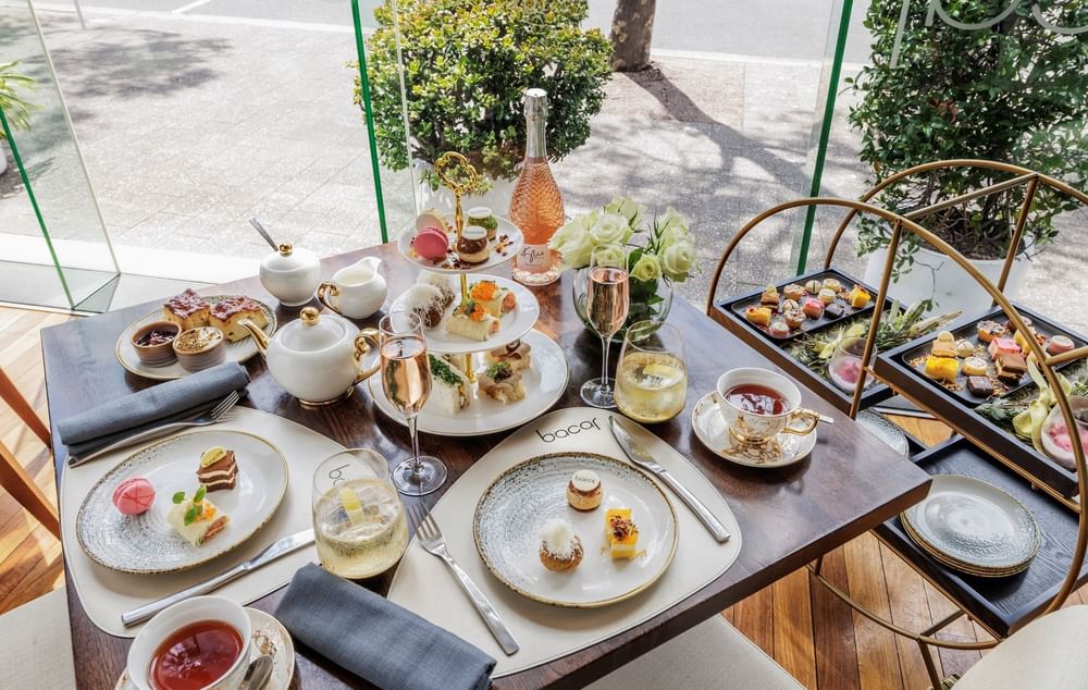 Brunch with pastries, tea, and champagne on a sunlit table in Bacar Restaurant & Bar at Pullman Sydney Olympic Park