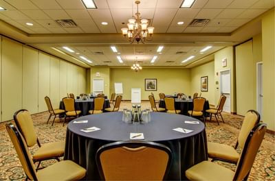 Banquet tables arranged in a meeting room with carpet floors at The Wildwood Hotel