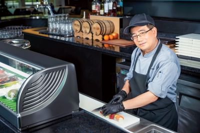 Chef making sushi in restaurant at Innovation Hotel