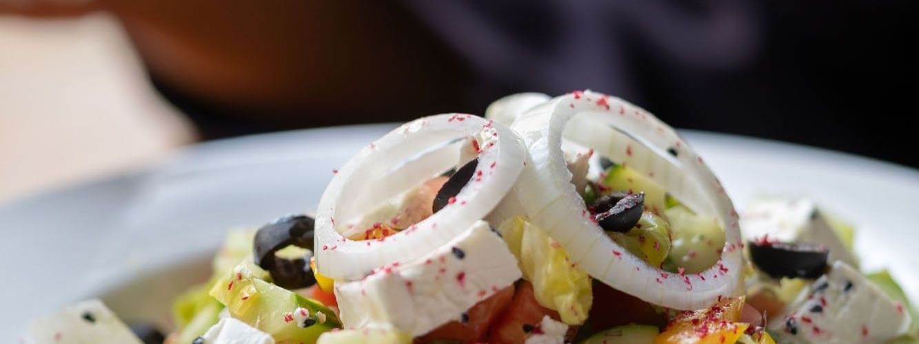 Close-up of a fresh salad featuring diced cucumber, onion rings, & feta cheese in Seasons Restaurant at Warwick Hotel Jeddah