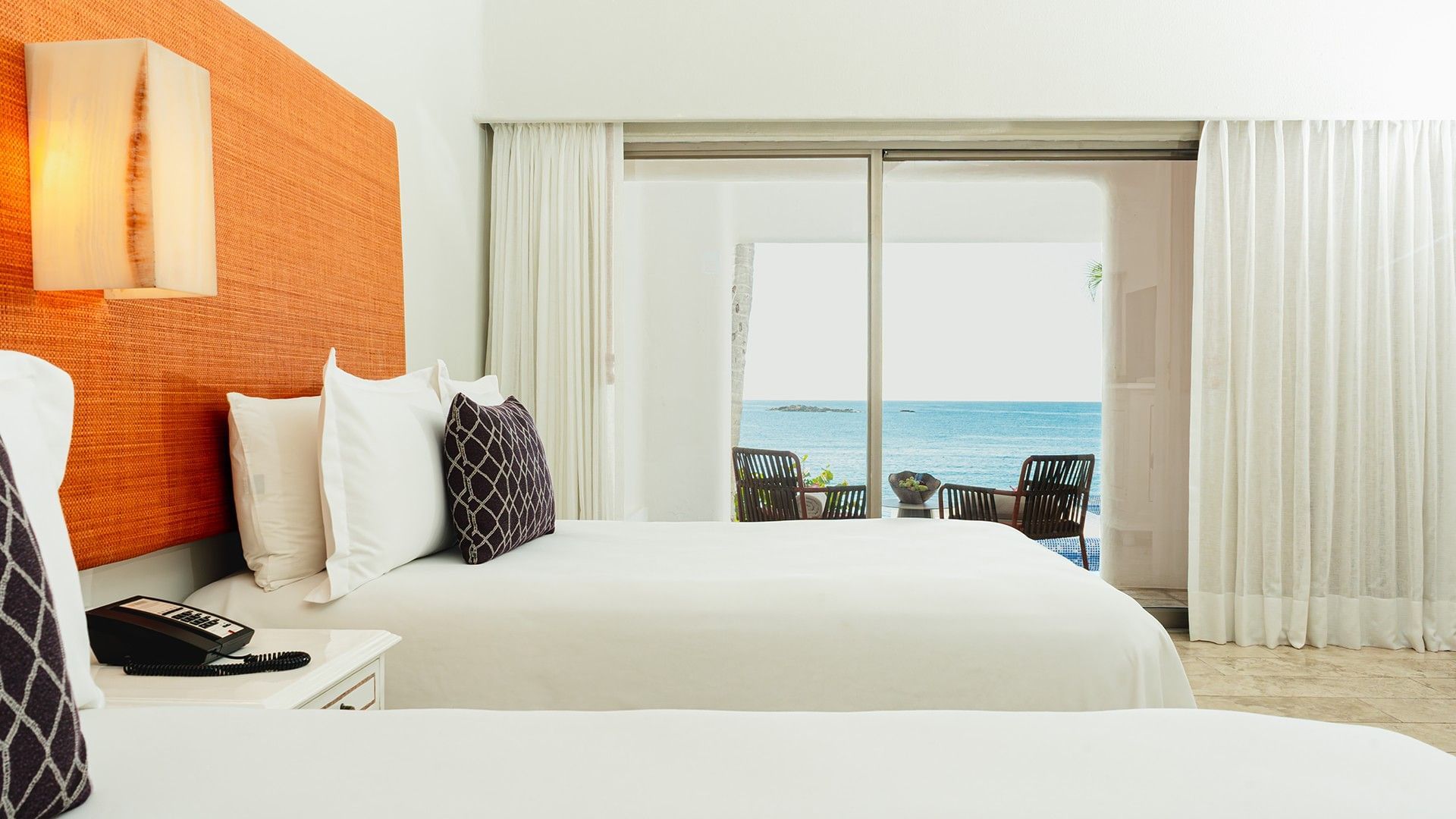 Nightstand by the bed in King Camino Real Club with private balcony seating & ocean views at Camino Real Zaashila Huatulco