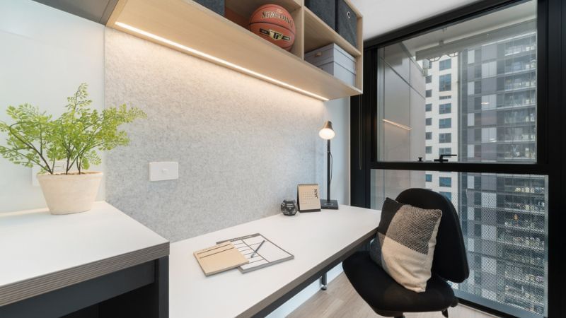 Modern office study with desk, chair and cityscape view.