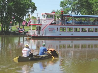 Two people riding a boat near Marv Herzog Hotel