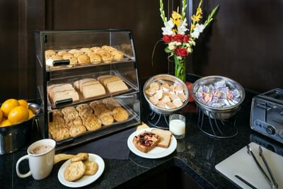 Arranged corner with food showcase with tea and snacks in Plaza Inn & Suites at Ashland Creek​
