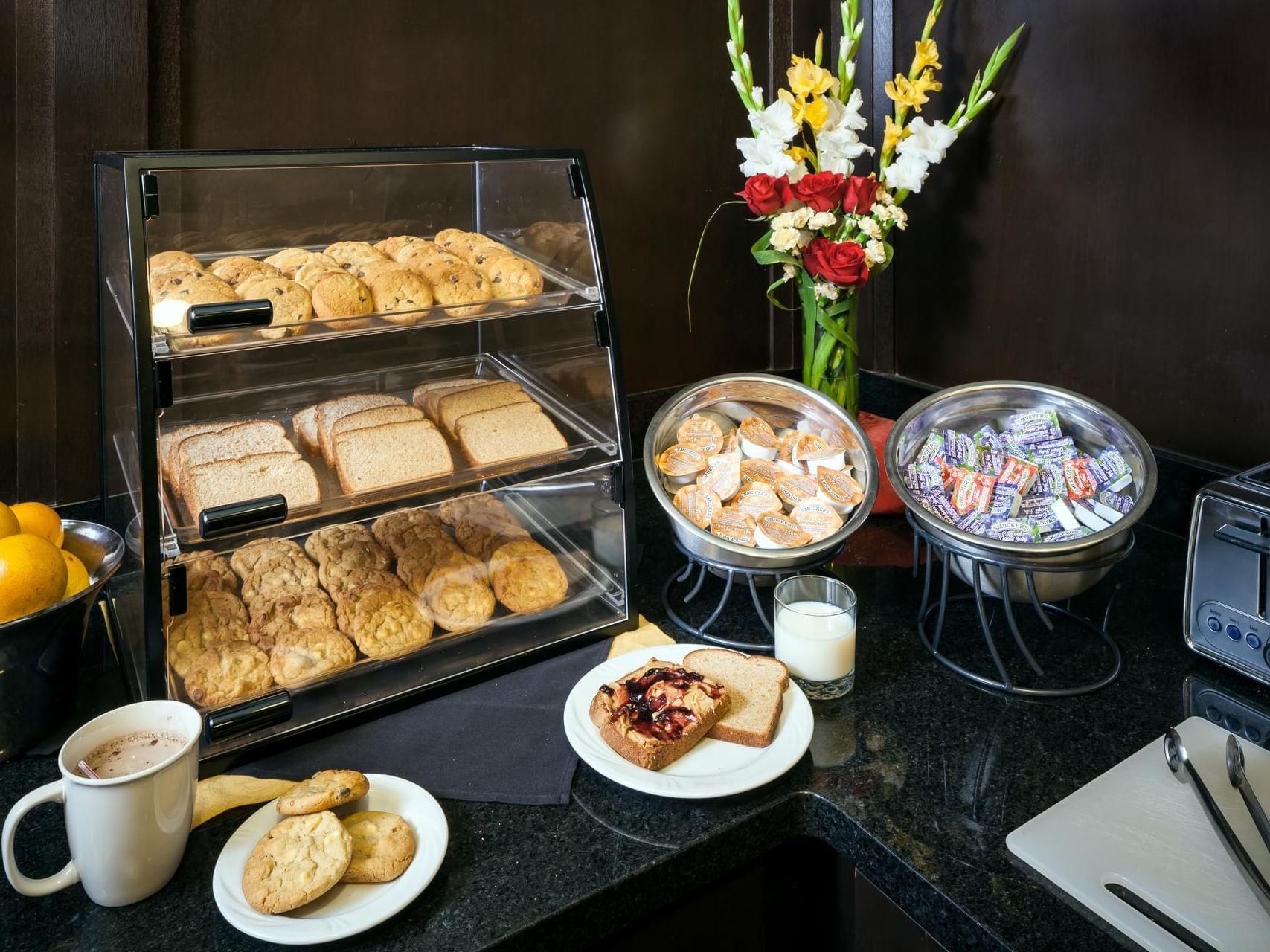 Arranged corner with food showcase with tea and snacks in Plaza Inn & Suites at Ashland Creek​