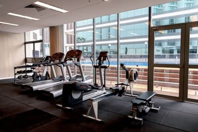Exercise machines arranged in fitness center at Amora Hotel Brisbane