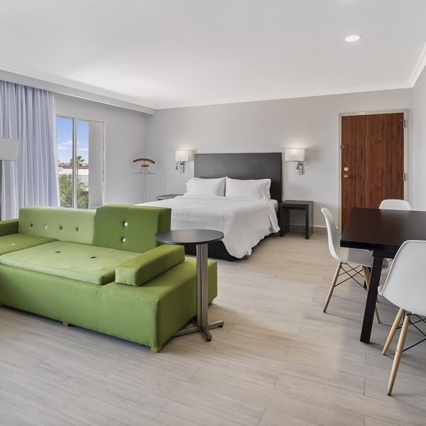 Junior Suite espaciosa, 1 King en Fiesta Inn Express Nuevo Laredo con cama queen, sofá y mesa de comedor moderna