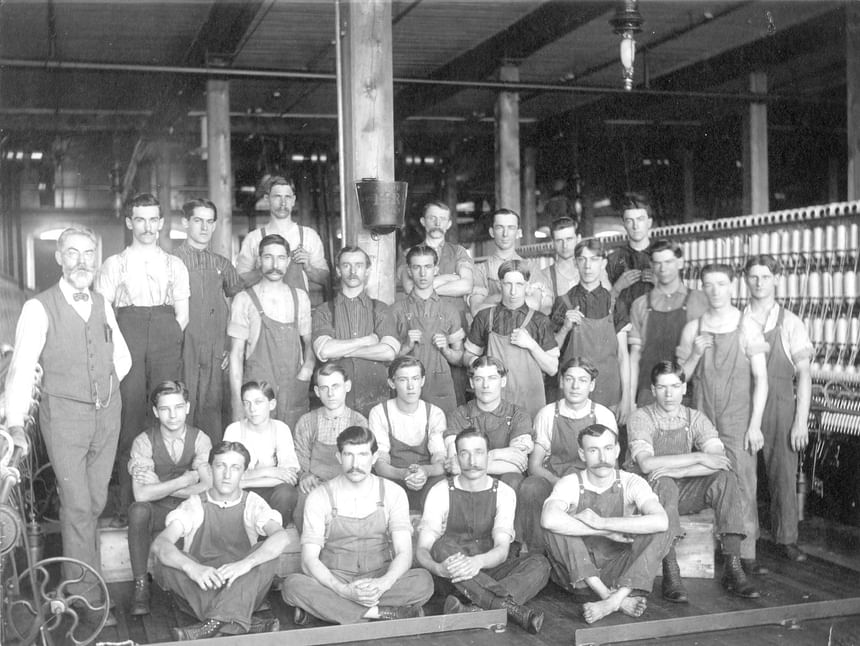 Black & white image of laborers in a Factory near Hotel Moco