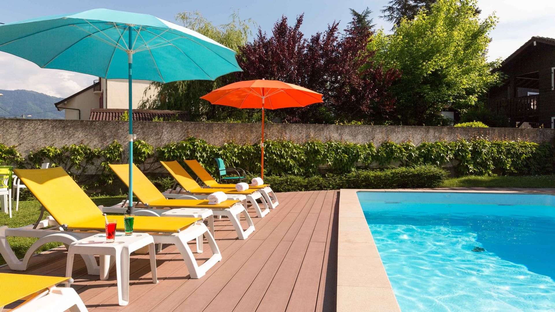 Lounge with sunbeds by the pool at Hotel L'Arc-En-Ciel