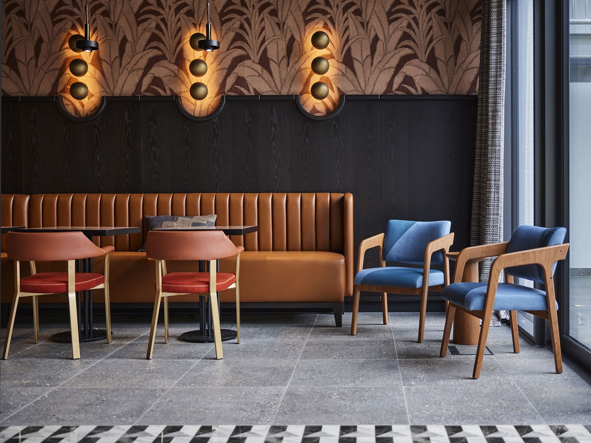 Lounge area with plush seating and tables in Winter Garden at Titanic Comfort Kurfürstendamm