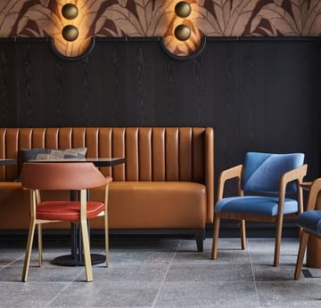 Lounge area with plush seating and tables in Winter Garden at Titanic Comfort Kurfürstendamm