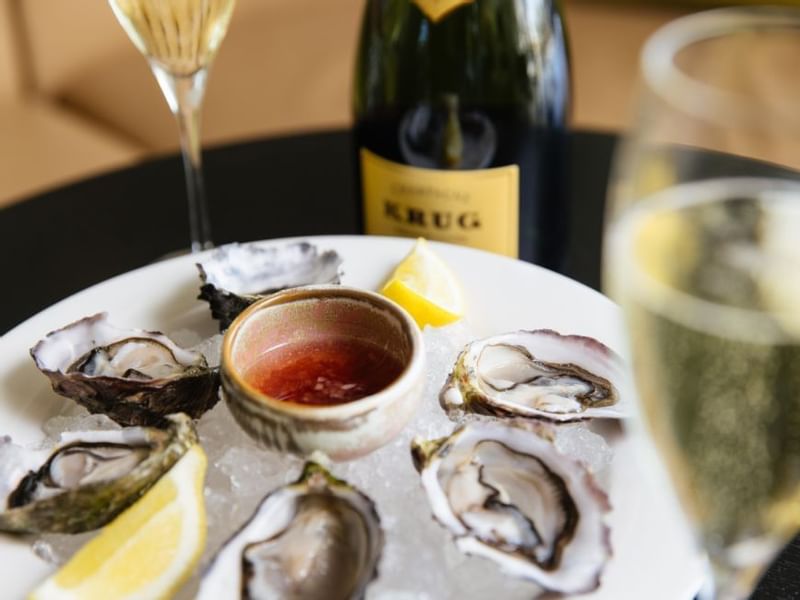 A plate of oysters with lemon and sauce, glass in Bistro Guillaume at 
Crown Metropol Perth