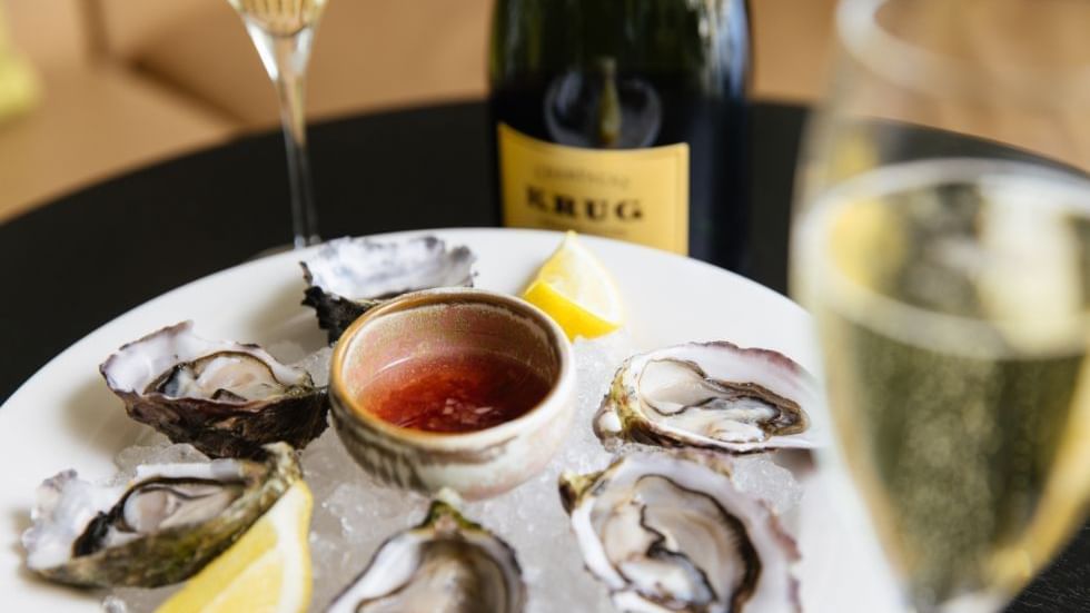 A plate of oysters with lemon and sauce, glass in Bistro Guillaume at 
Crown Metropol Perth