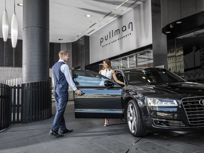 Concierge opening the car door for a lady at Pullman & Mercure Brisbane King George Square