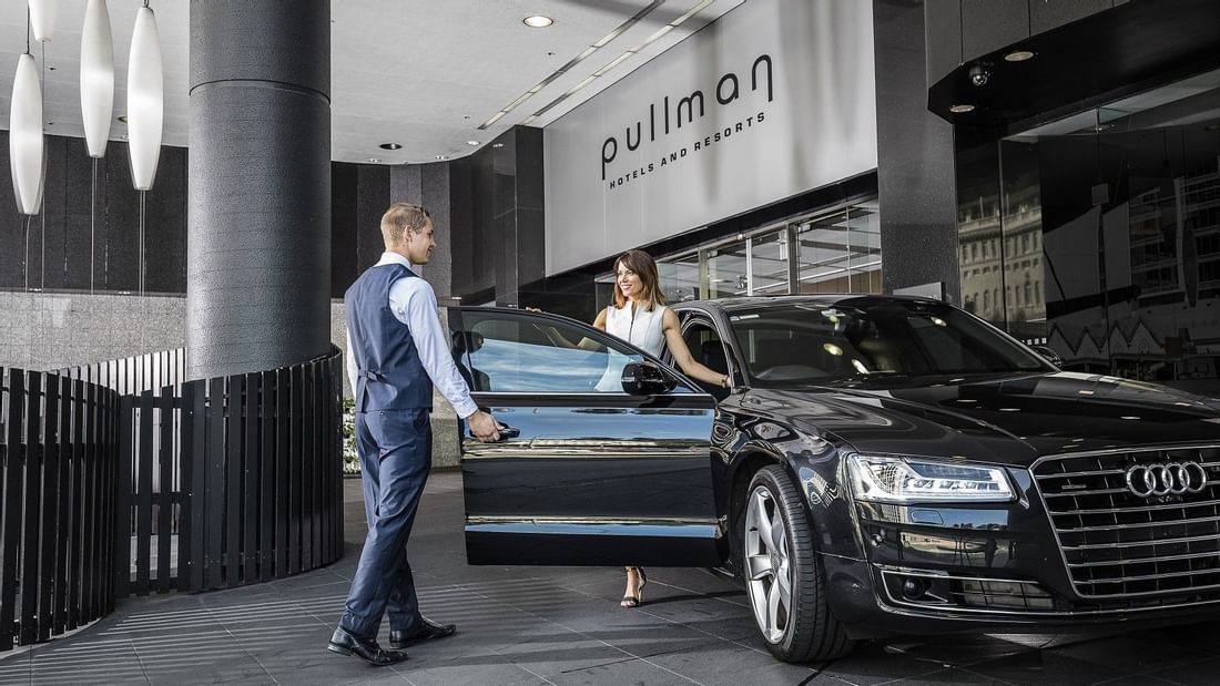 Concierge opening the car door for a lady at Pullman & Mercure Brisbane King George Square