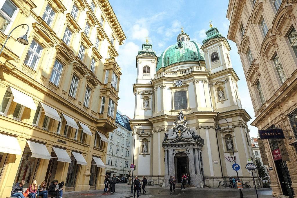 Baroque St. Peter’s Church in Vienna’s historic city center with its green dome, surrounded by narrow streets and historic buildings.