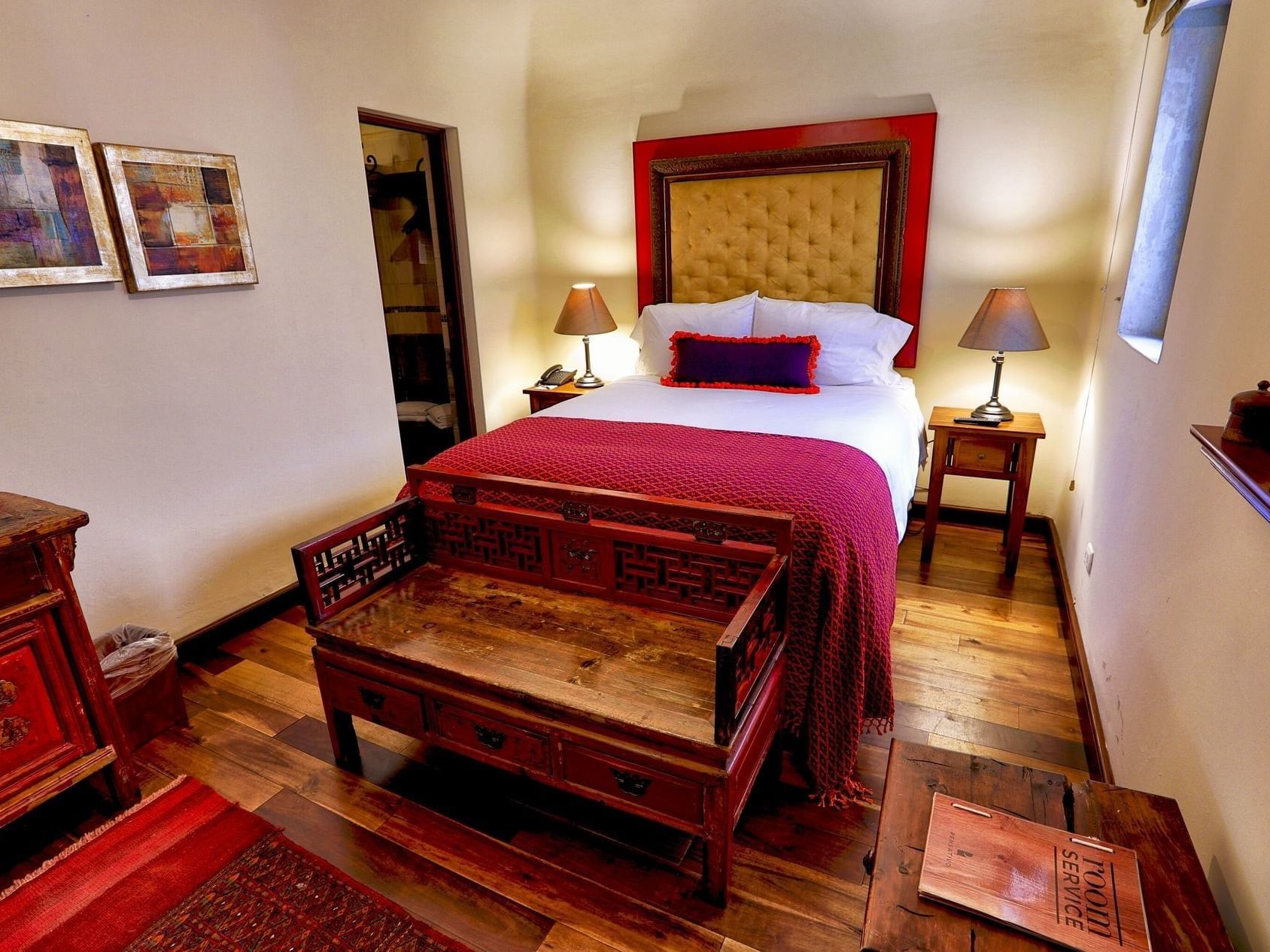 Bed with cushioned headboard & wooden floors in Deluxe 1 Double at Pensativo House Hotel