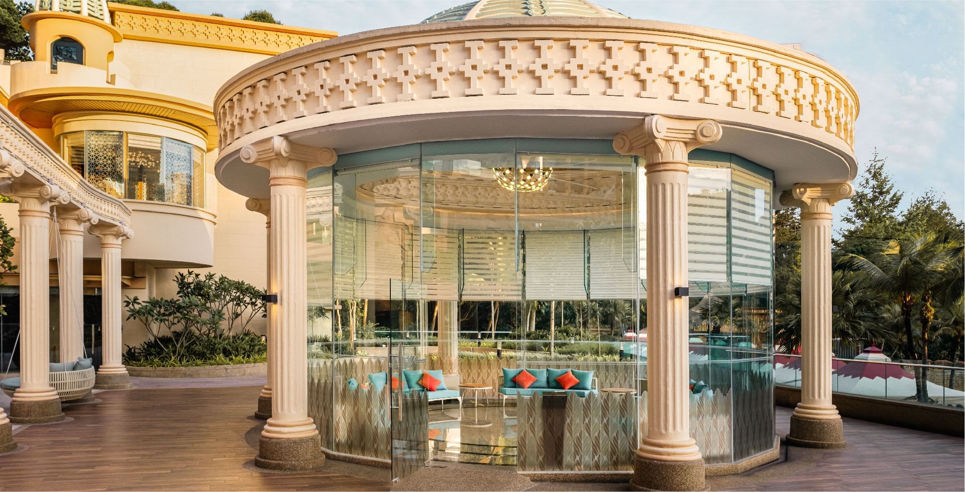 Elegant glass pavilion at Sunway resort, featuring classical columns and comfortable seating overlooking the resort