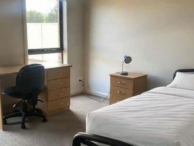 Simple room with single bed, desk, chair, and nightstand at La Trobe University Regional Housing – Mildura.