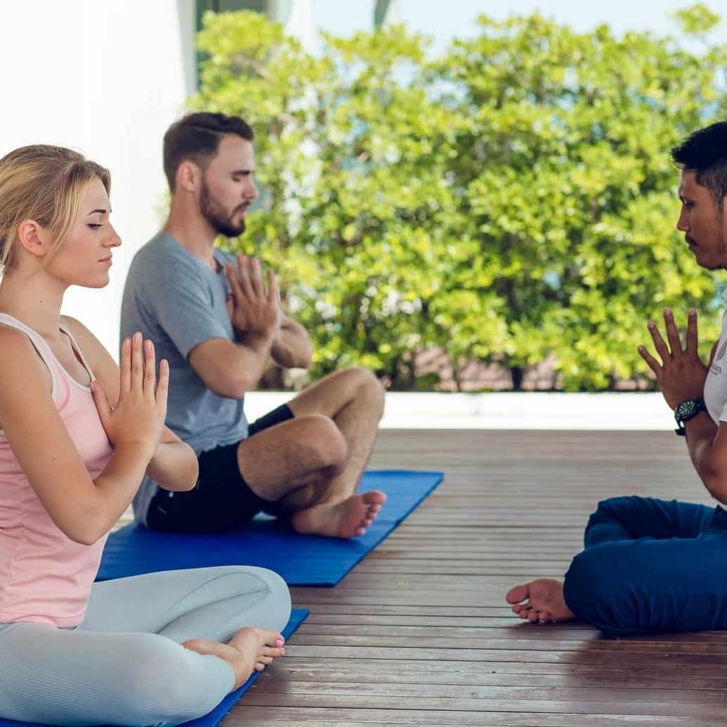 Three people meditating at Amatara Wellness Resort Phuket