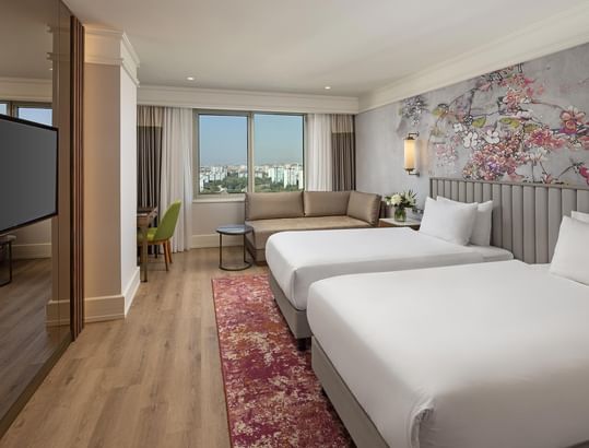 Titanic Port Bakırköy’de Deluxe City View Room’da ikiz yataklar, TV ve şehir manzaralı çalışma alanı.