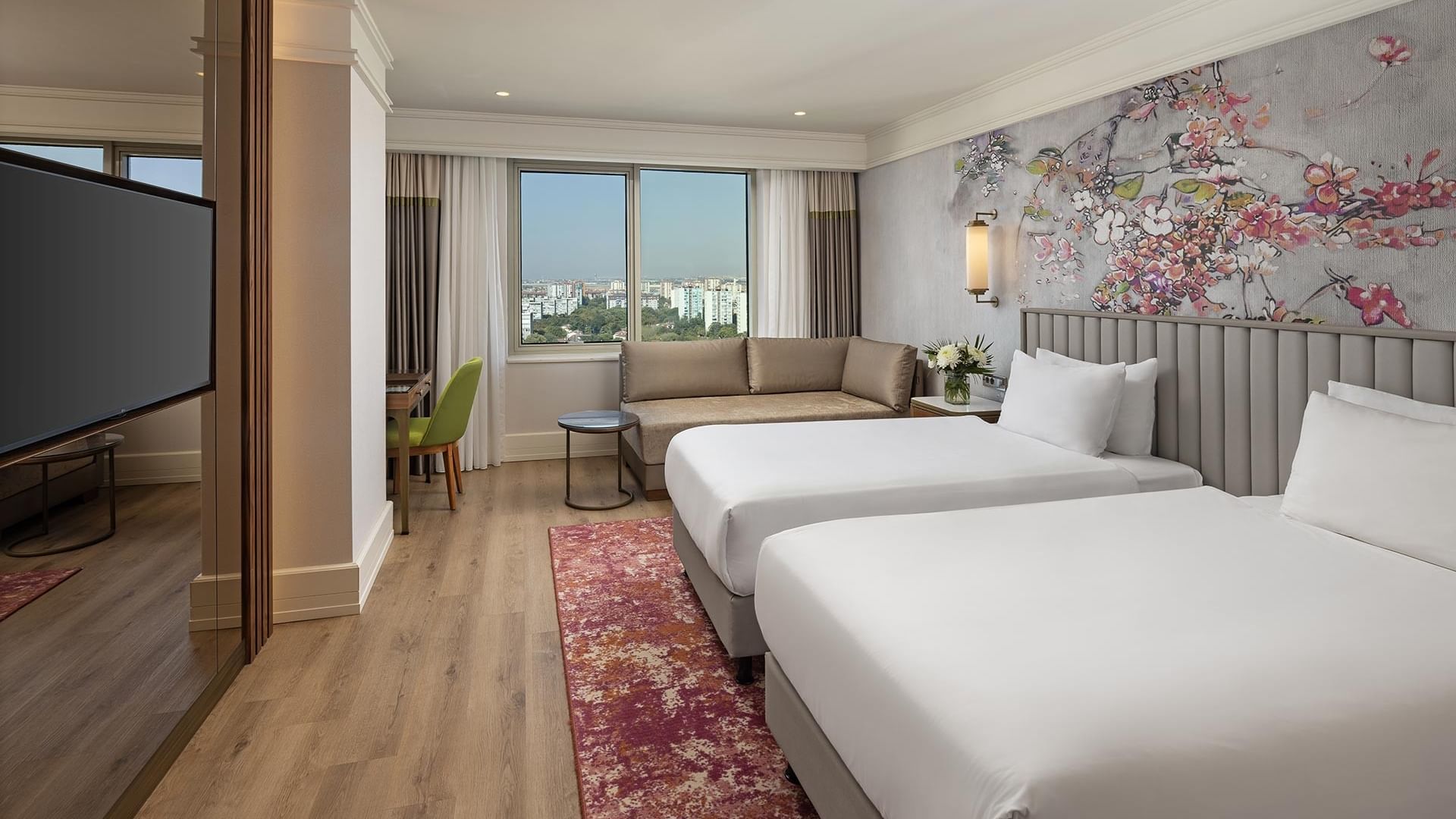 Titanic Port Bakırköy’de Deluxe City View Room’da ikiz yataklar, TV ve şehir manzaralı çalışma alanı.