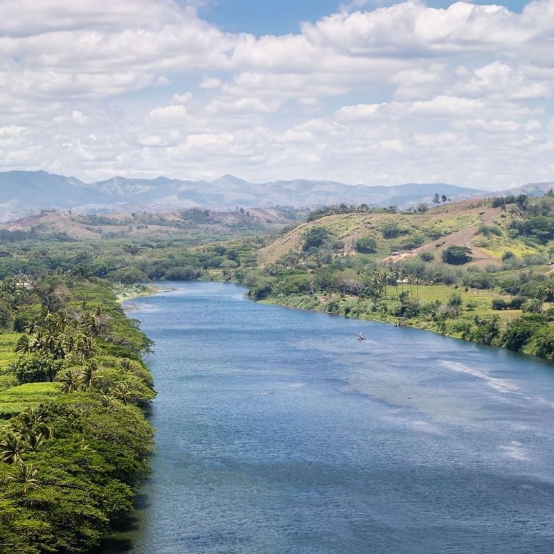 Sigatoka River by tropical green banks under a vast mountain range near The Naviti Resort - Fiji