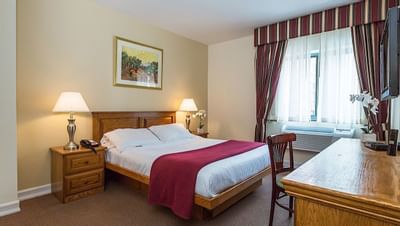 Queen bed & work desk in Queen Room at Chelsea Savoy Hotel