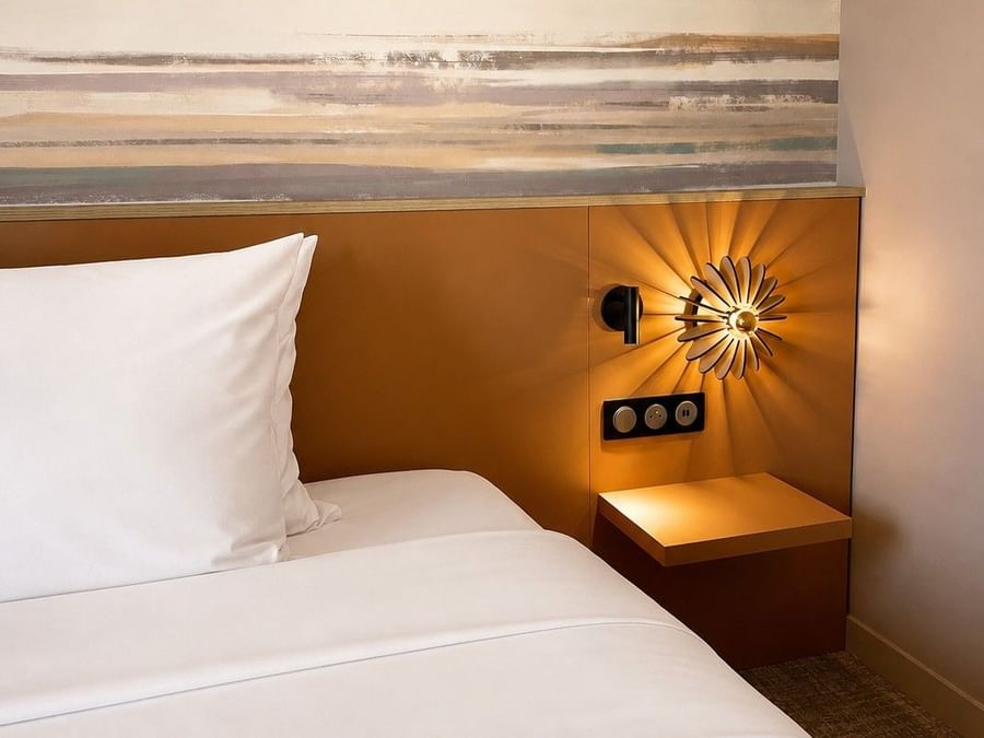 Lit confortable avec une lampe design au Osmo Hôtel, Chantepie.