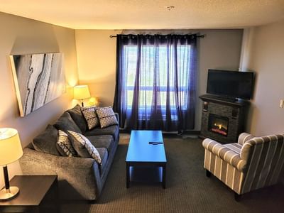 Fireplace by TV lounge area in Romantic Spa Suite at Service Plus Inns & Suites Drayton Valley