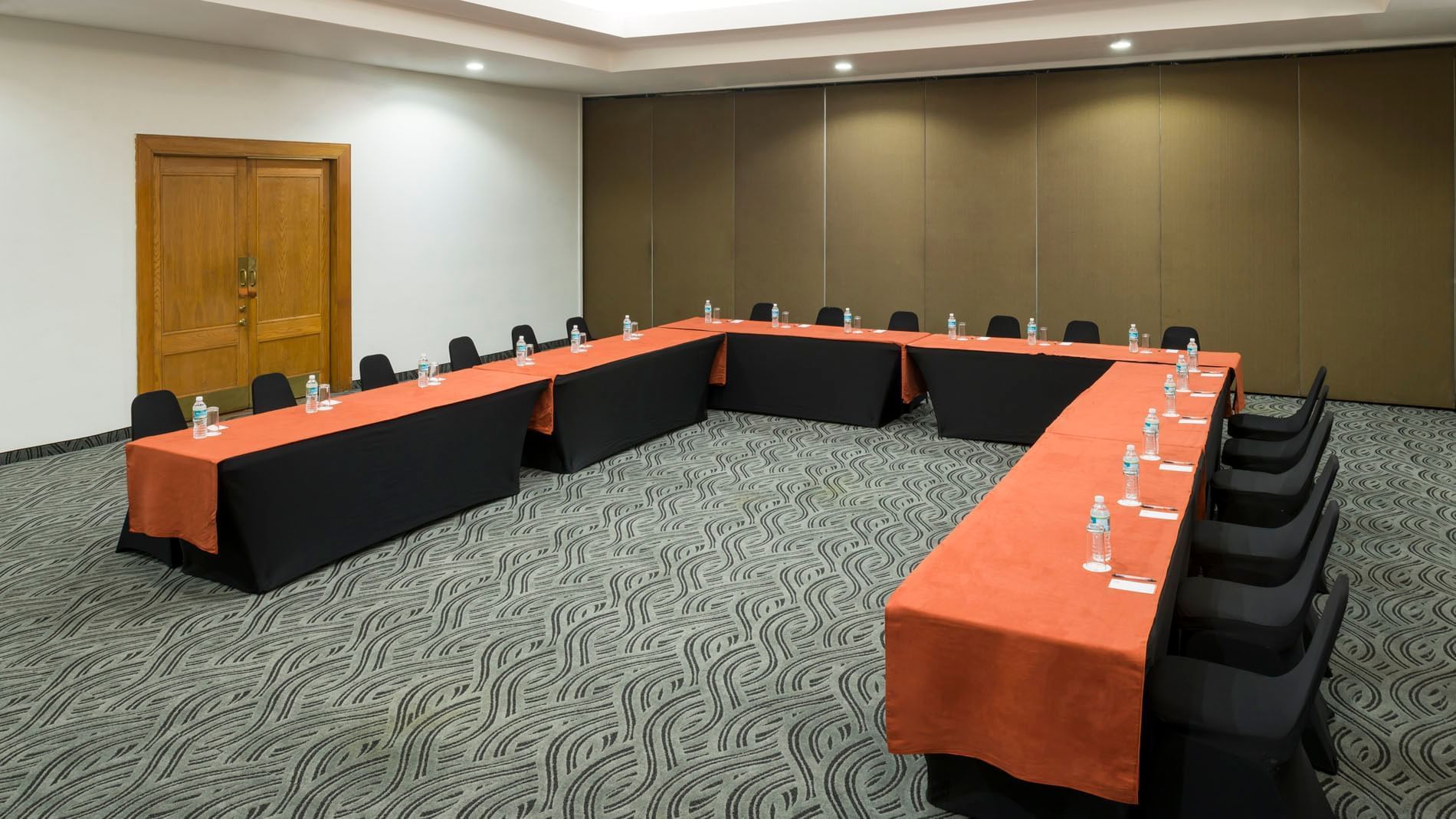 U-shaped table setup by the door and carpet floors in Budapest at Real Inn Mexicali