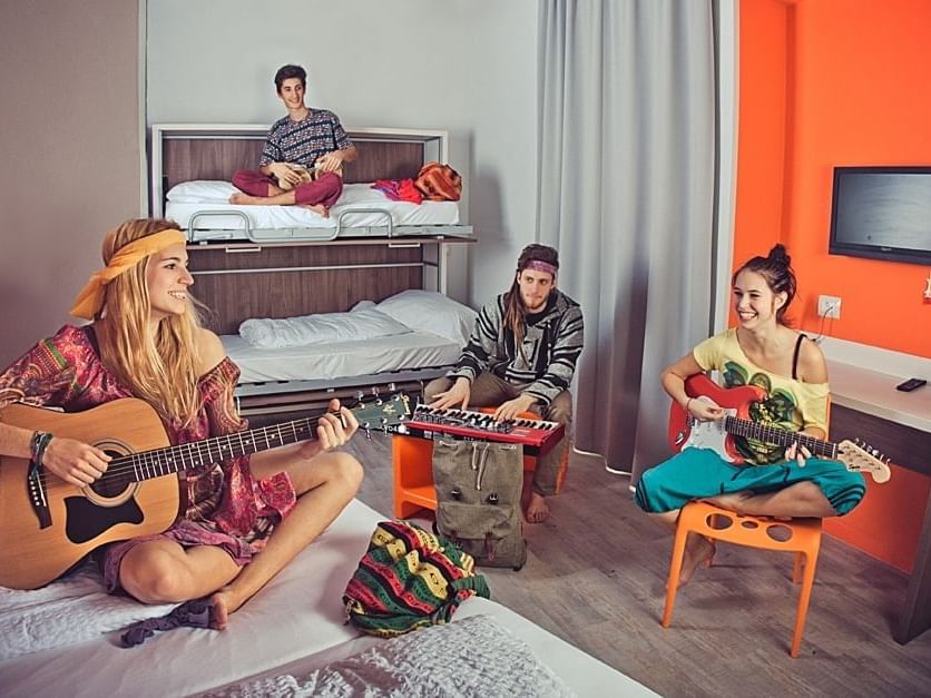 Four people playing musical instruments in Reggae room at Hotel Nologo