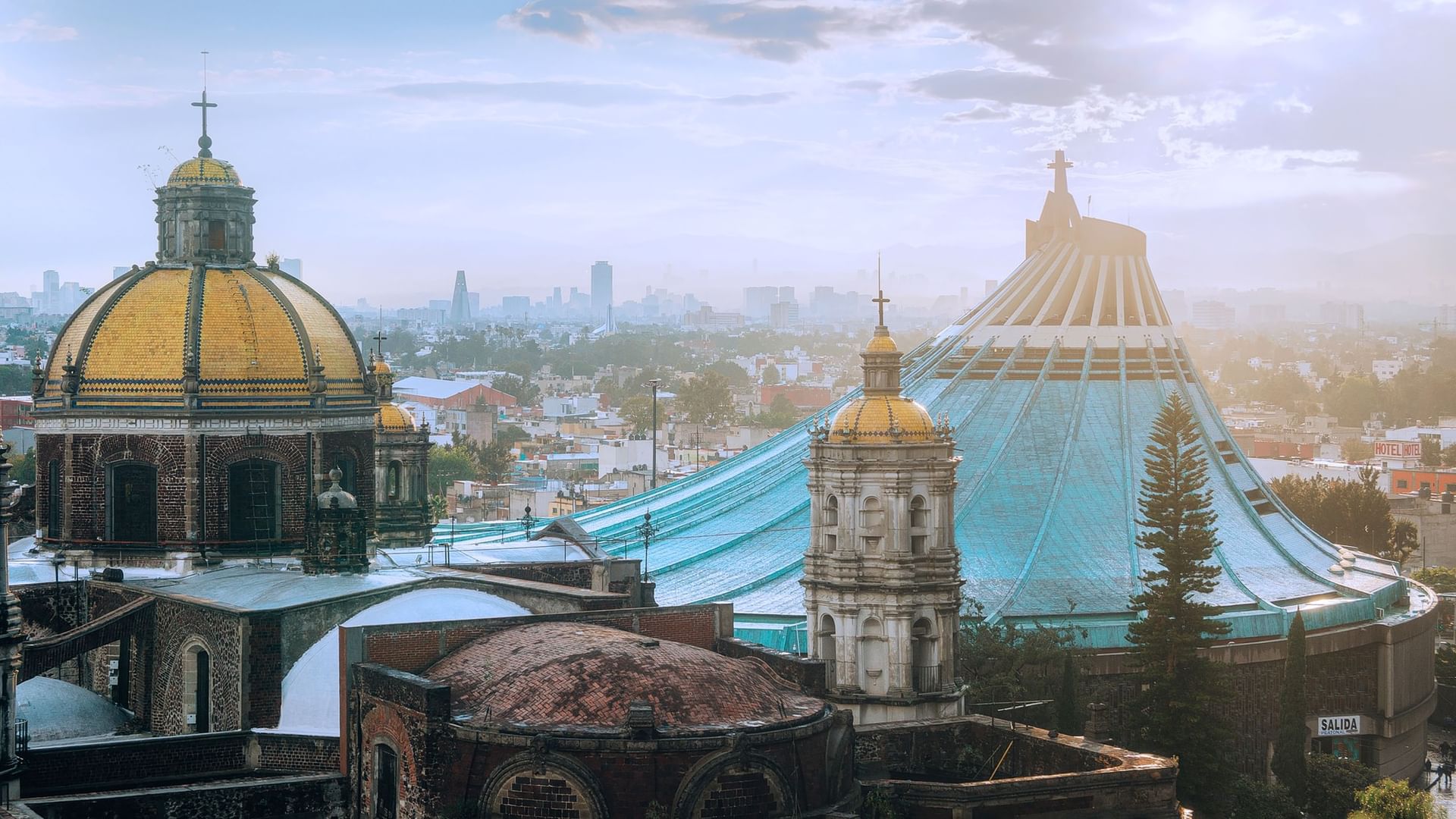 Skyline view of historic domes and a modern blue cathedral at Camino Real Hotels