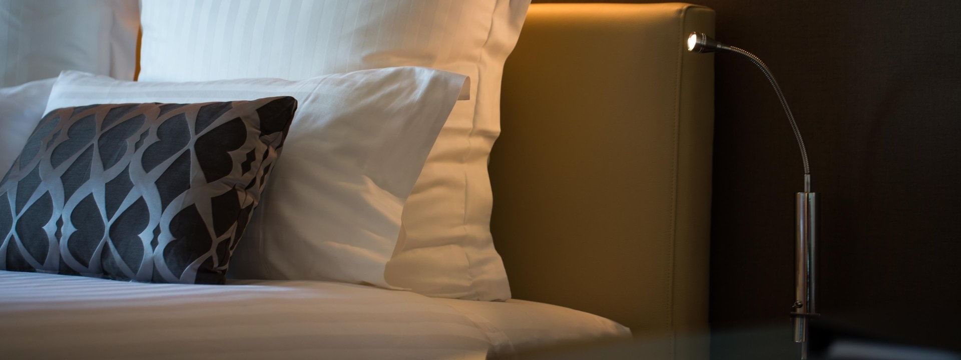 Close-up of bed & nightstand in a Room at Pullman Olympic park